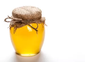 Glass jar full of honey on a white background