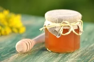 28651476 – jar of delicious honey with rapeseed flowers and honey dipper