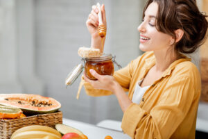 Woman eating honey at home